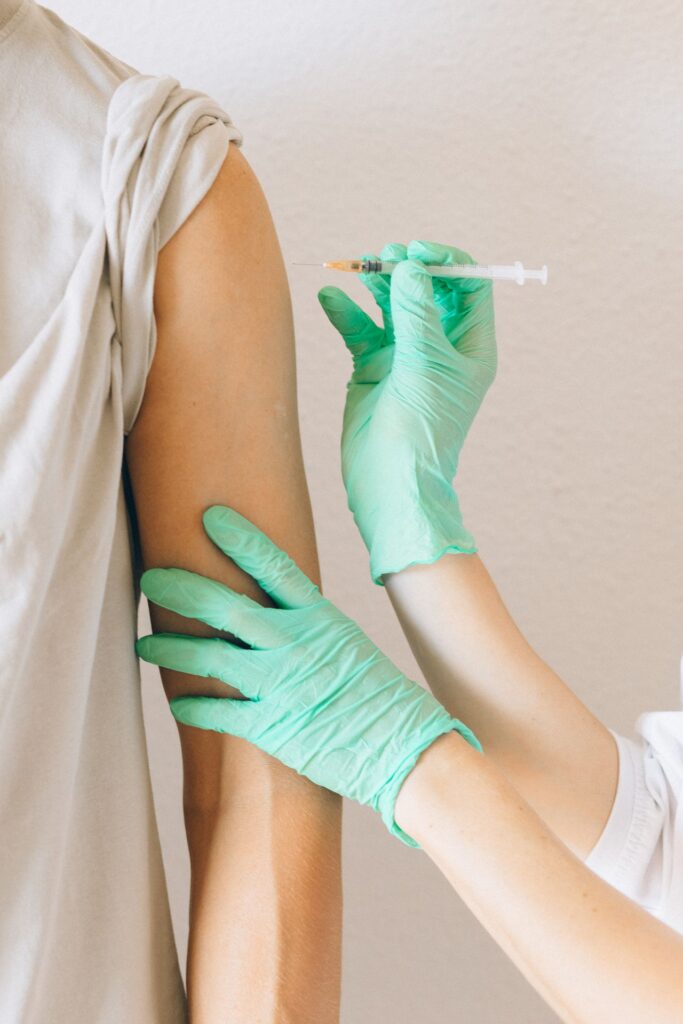 Profissional de saúde aplicando a vacina tríplice viral no braço de um paciente, proteção contra o sarampo